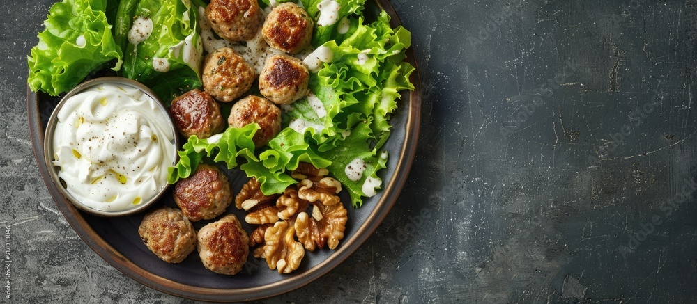 Poster a food display featuring lettuce meatballs white sauce and walnuts arranged beautifully on a plate w