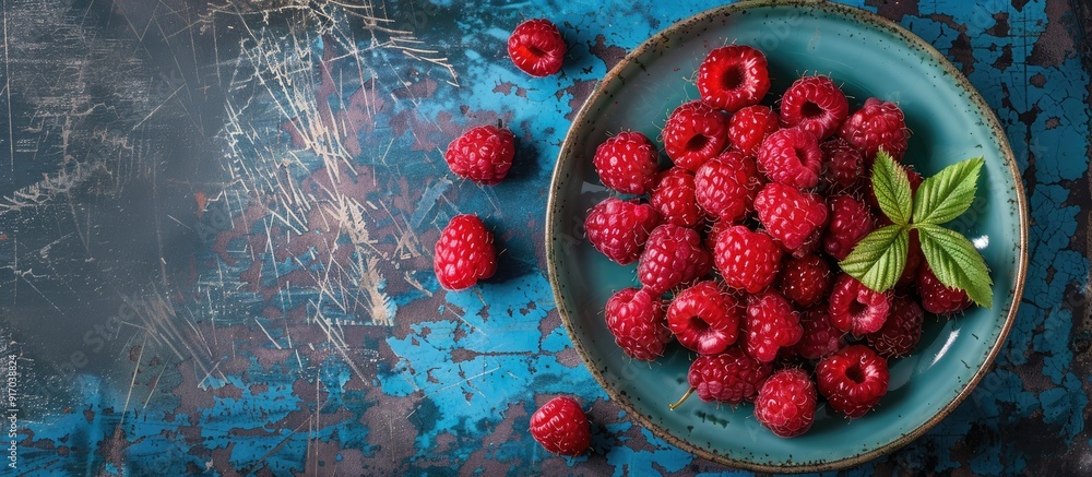 Aufkleber a ceramic plate with fresh raspberries on a rustic blue desk providing a perfect background for a co