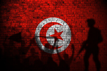 tunisia flag painting on brick wall and Protesters shadow
