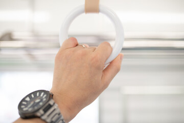 Fototapeta premium 電車の吊革につかまる男性の手