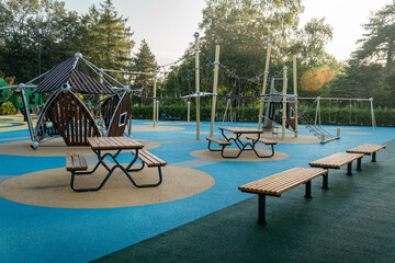 Early morning in a public park featuring playground equipment and benches