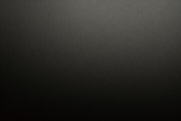 Texture of old gray paper closeup. Structure of a dense cardboard. The black background.