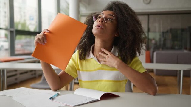 Suffering sweaty African American girl female student business woman businesswoman in office school university library college studying work problem high temperature climate control conditioner broken