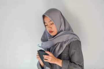 Close up portrait of an Indonesian woman holding a wallet and counting the money inside