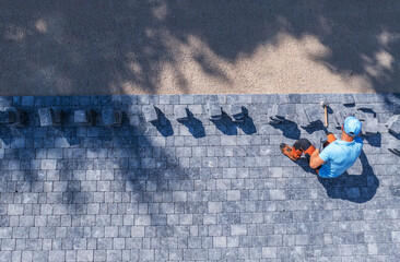 Worker Laying Pavers on a Sunlit Pathway at a Construction Site in the Afternoon