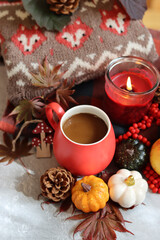 Autumn still life with red mug and warm brown knitted sweater. Cloe up photo of colorful autumn composition. 