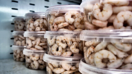 Many peeled shrimps in brine on a fridge shelf
