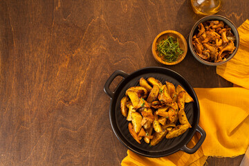 Vegetarian dish fried potatoes with garlic, parsley and chanterelle mushrooms closeup on a plate on the table. horizontal