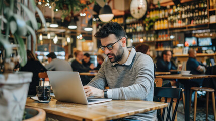 Professional working on laptop in a busy coffee shop