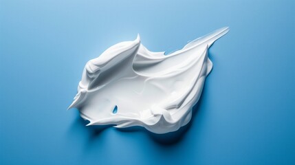 A white blob of cream is spread across a blue background
