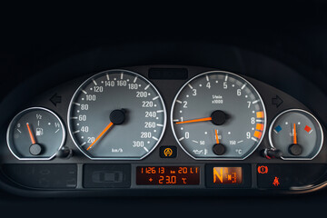 Sports car tachometer and dashboard with backlight. Close-up view of the modern car dashboard. Arrow of speedometer of supercar 