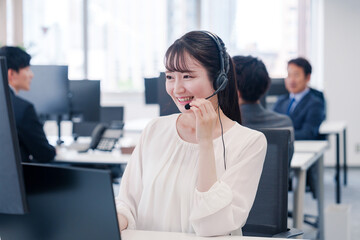 ヘッドセットをつけて話す若いビジネスウーマン