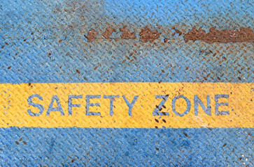 safety zone border on metal diamond plate floor, yellow bar boundary on grunge blue steel sheet,...