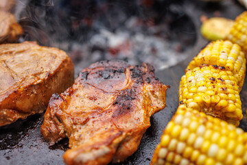 Delicious meat steaks and vegetables on the grill in the garden close-up,