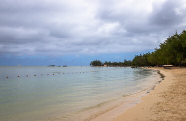 Exposure of the beautiful Mon Choisy Beach, located ion the northwest of the Mauritius Island, a long stretch of soft white sand curves around a turquoise bay fringed by casuarina trees