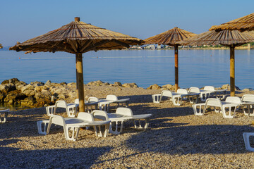 Empty beach with sun loungers and umbrellas, summer vacation
