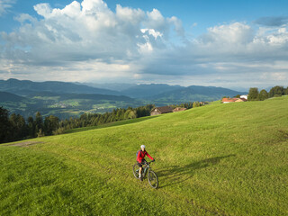 Fototapeta premium pretty senior woman riding her electric mountain bike in the Allgaeu mountains near Oberstaufen and Stiefenhofen, Bavaria, Germany