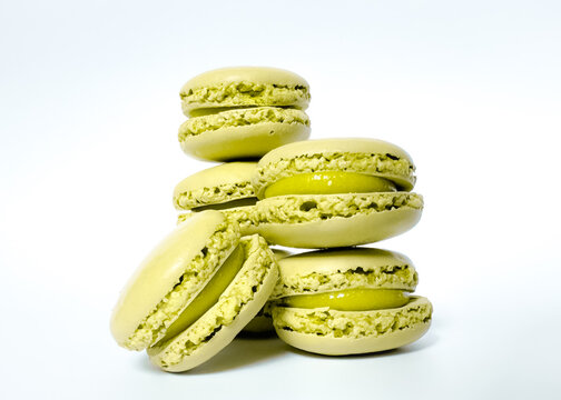 Green pistachio macaron isolated on white background with shadow. Macaroons, sweets isolated on white background.