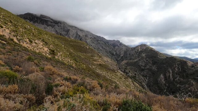 Fog and clouds on hiking trail to Maroma peak in thunderstorm day, Sierra Tejeda, Spain 