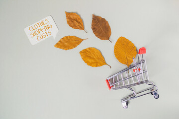 A shopping cart is on a table with leaves