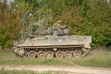 Fototapeta premium close-up of a soldier in a British army FV510 Warrior Infantry Fighting Vehicle with guns on a battle exercise