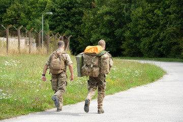 Fototapeta premium close-up of two army soldiers tabbing with 40Kg and 25Kg bergens