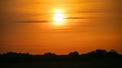 A breathtaking golden sunset over a serene rural landscape, perfect for illustrating summer evenings or environmental awareness themes
