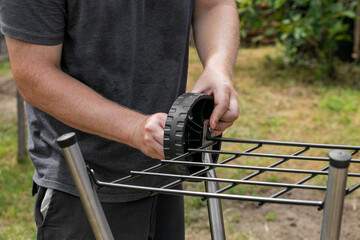 A person assembling a garden cart in a backyard, emphasizing DIY and home improvement projects during summer