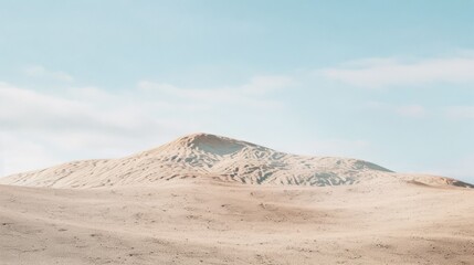 Naklejka premium Expansive sand dunes under a clear blue sky, capturing the serene, endless beauty of the desert landscape.