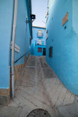 A tranquil alley in J&uacute;zcar, Spain, lined with vibrant blue buildings, capturing the unique charm of the "Smurf Village." Perfect for travel, architecture, or cultural themes.