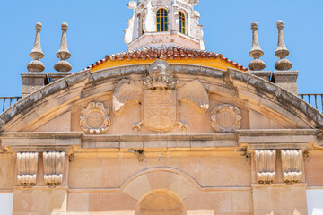 A close-up view of a historic church bell tower in Ronda, Spain, featuring classic yellow and white architectural details against a clear blue sky. Ideal for cultural and architectural themes.