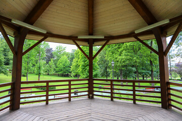 Fototapeta premium WIELICZKA, POLAND - 12 JULY 2022: Wooden gazebo in beautiful city park by the Salt Mine, Wieliczka, Poland.