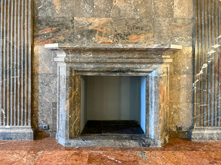 Classic stone marble fireplace in the interior of a luxurious historical building