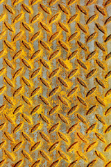 Textured Background of a Rusty Corrugated Metal Sheet With a Diamond Pattern, Giving an Industrial...