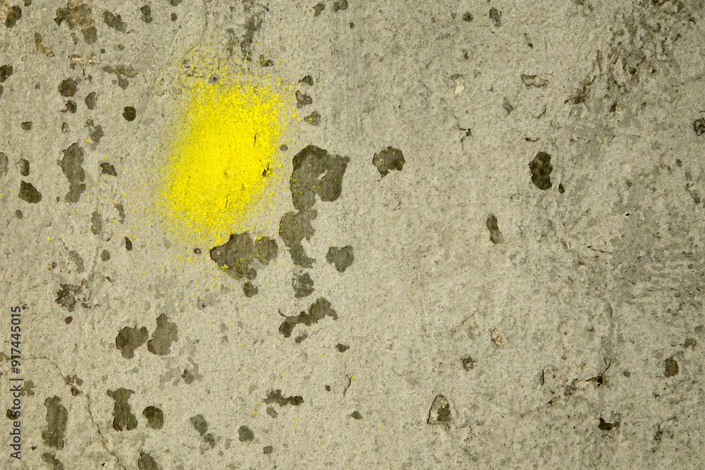 Poster textured plaster wall with yellow paint splatter in a rustic setting