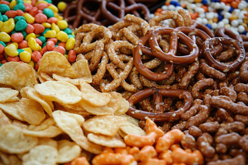 An assortment of savory snacks including chips, crackers, pretzels, and nuts