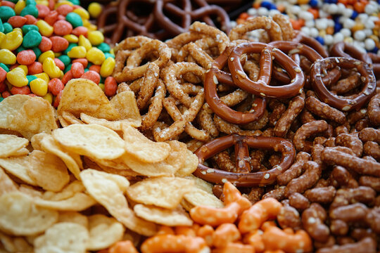 An assortment of savory snacks including chips, crackers, pretzels, and nuts