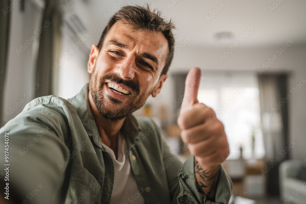 Wall mural self portrait of adult excited man stand and thumb up gesture at home