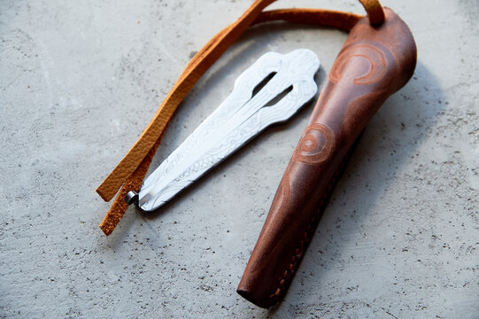 Jew's harp in a brown genuine leather case on a gray background. Sound therapy.