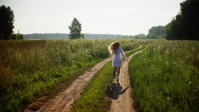 Woman running through lush green fields in slow motion