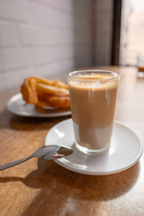 Freshly baked Churros with a glass of coffee with milk