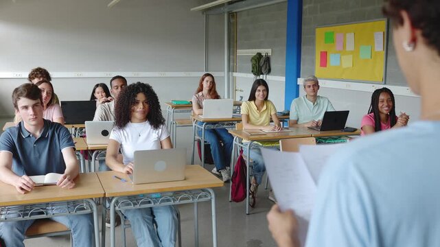 Group of diverse high school students applauding to their classmate after giving a presentation in classroom. Education concept.