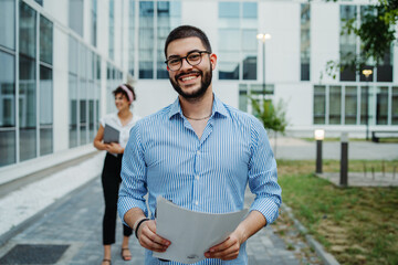 Two smiling business people going to work to modern business building