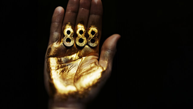 Eine Hand mit goldenen zahlen 888