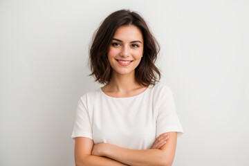 Overjoyed woman standing with arms crossed against light background 