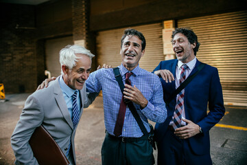 Businessmen laughing and enjoying a moment together outdoors