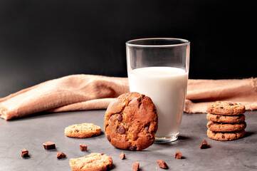 deliciosos cookies artesanais em fundo rústico com gotas de chocolate e um copo de leite, 