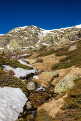 Snowy high mountain landscape in the sierra de guadarrama with snowmelt river. Concept: Travel, hiking, nature.