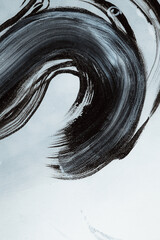 Dark brush strokes on a textured canvas. Black and white abstract background. A fragment of an...