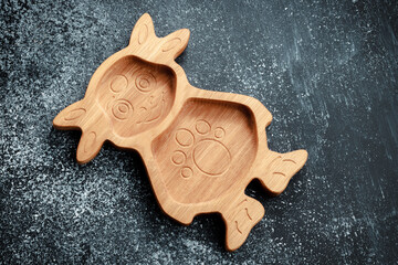 The children's plate in the shape of a cartoon character is made of wood for serving snacks,...